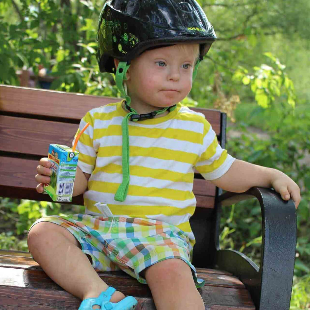 Niño sentado con un casco y un jugo